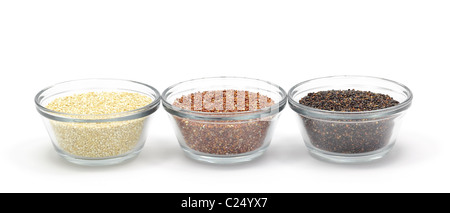 Yellow, red, and black quinoa in glass bowls isolated on a white background. Stock Photo