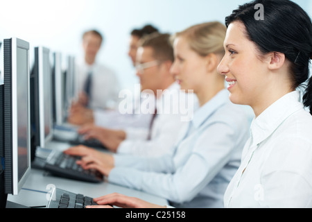 Close-up of a happy businesswoman working on computer among the others Stock Photo