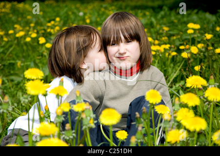 sisters in the dandelions - spring Stock Photo