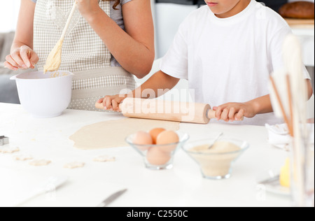Close up of mother and son preparing a dough together Stock Photo