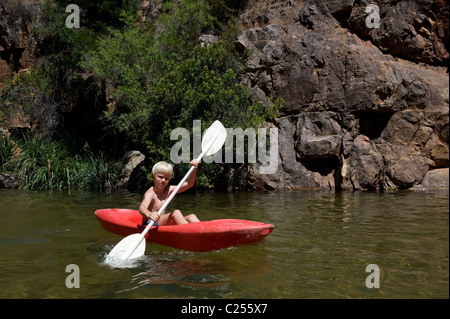 Boy paddling in a canoe on the Rondegat River, Cedarberg, Western Cape, South Africa Stock Photo