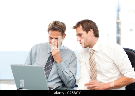 Two concentrated businessmen working together on a laptop Stock Photo