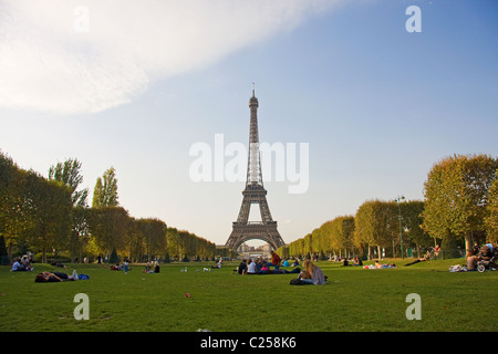 Parisians relax in the Parc du Champ de Mars, with the Eiffel Tower beyond Stock Photo