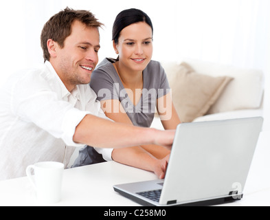 Cute man showing something on the laptop screen to his girlfriend Cute man showing something on the laptop screen to his girlfriend