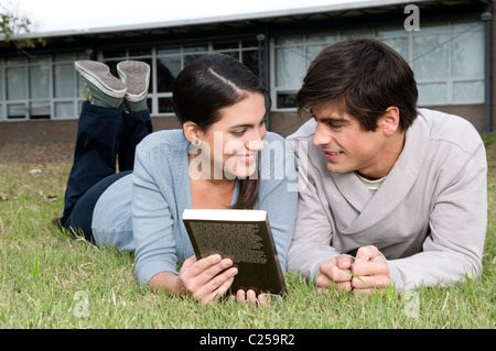 Young couple reading a book in campus Stock Photo