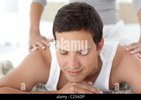 Peaceful man being massaged by his girlfriend on their bed Stock Photo