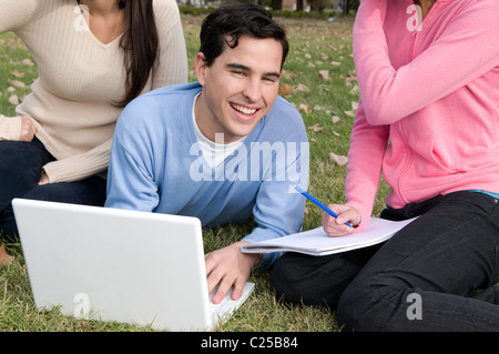 Students, at, campus, university, field, studying, pod, mp3, park, outdoors, sun, friends, having, fun. Stock Photo