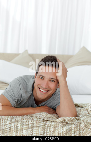 Portrait of a cheerful man lying on his bed Stock Photo
