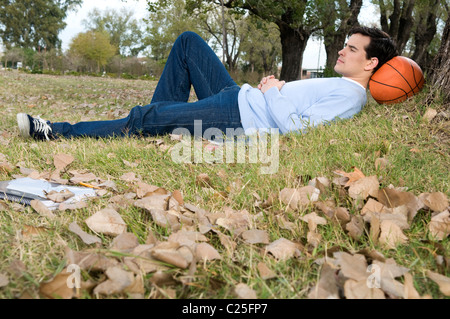 Man, Sports, campus, university, basket’s, basketball’s, ball, rest, play, playing, practice, practicing, park, trees, nature. Stock Photo