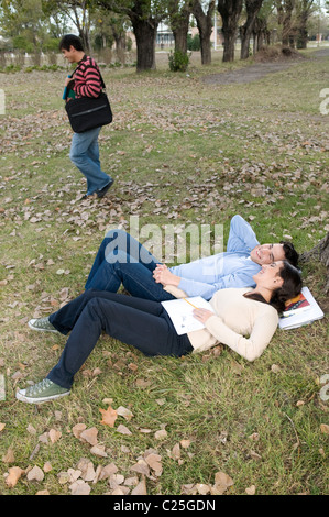 Image, man, and, woman, dream, dreaming, American, Caucasian, lay, laying, down, at, campus, university, the, grass, floor. Stock Photo