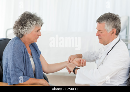 A senior doctor doing a check-up to his patient Stock Photo