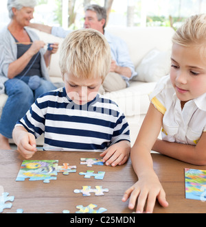 Children playing puzzle in the living room Stock Photo