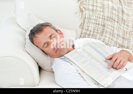Exhausted man sleeping on the couch at home Stock Photo