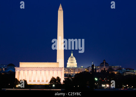 WASHINGTON DC, United States — A panoramic view of Washington DC's National Mall showcases iconic monuments from left to right: the Lincoln Memorial, Washington Monument, and US Capitol Building. This 2.3-mile stretch of American history and democracy is compressed by a telephoto lens, as seen from near the Iwo Jima Memorial in Arlington, VA, looking east across the Potomac River. Stock Photo