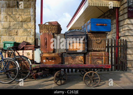 Old suitcases  and wicker baskets on a luggage trolley at Ramsbottom Railway Station on the East Lancs Railway Stock Photo