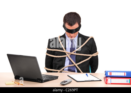A businessman tied up with rope in his office Stock Photo