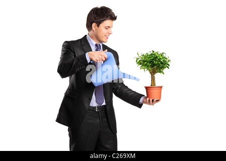 Portrait of a businessman holding a flower pot with benjamin and watering can Stock Photo