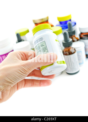 Hand holding medicine bottle to read label Stock Photo