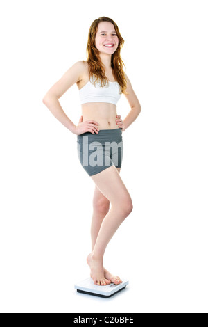 Smiling fit young woman standing on bathroom scale isolated on white Stock Photo