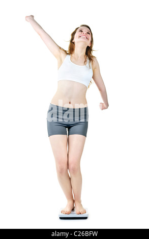 Happy joyful young woman standing on bathroom scale isolated on white Stock Photo