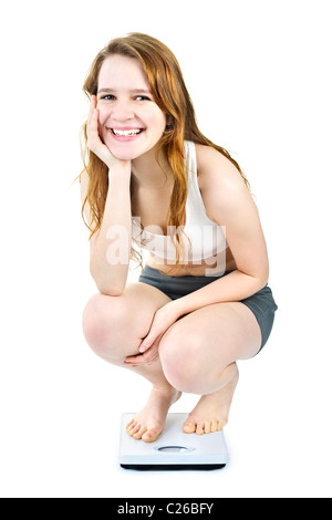 Healthy happy young woman crouching on bathroom scale isolated on white Stock Photo