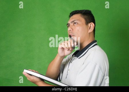 a man thinking something while holding a book Stock Photo
