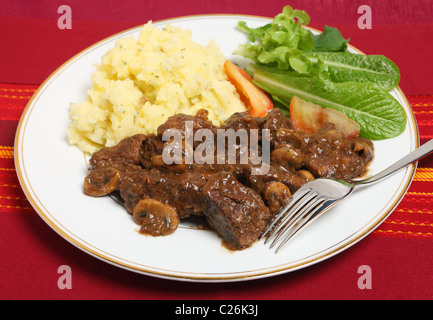 Beef Bourguignon - beef braised in a wine sauce and finished with fried mushrooms - with parsley potatoes and a salad Stock Photo