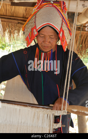 Akha woman weaving on her loom, Chiang Rai, Thailand Stock Photo