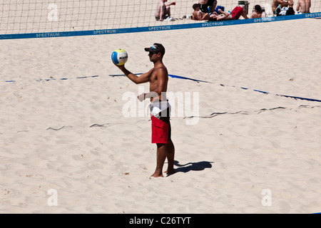 A player getting ready to serve in a beach volleyball match Stock Photo