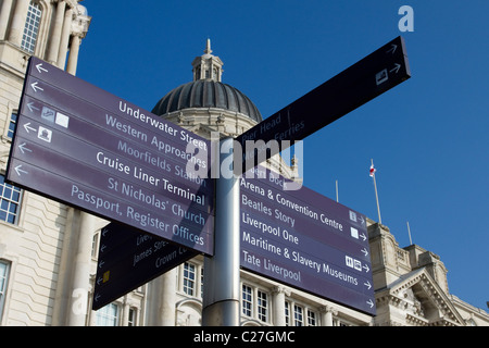 Street sign with different destinations. Multi-Directional,  Pier Head Tourist Signpost and the Port of Liverpool Building,  Liverpool, Merseyside, UK Stock Photo