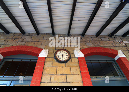 Wall clock on wall of abandoned train station Stock Photo
