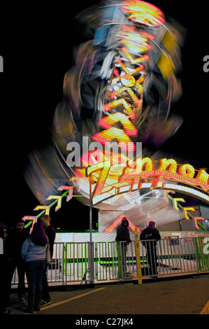The colorful lights of a fast moving carnival ride motion blur to form ...