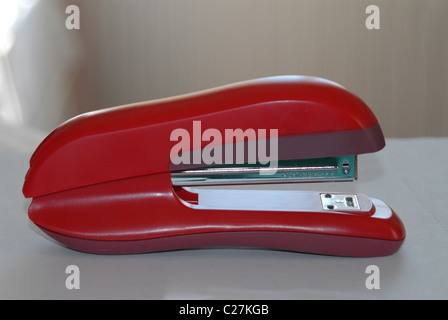 A red stapler on a desk. Stock Photo