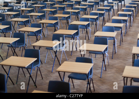 Desks and chairs set out for exams in a school hall, UK. Stock Photo