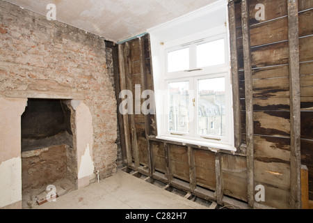 Brick wall, stud wall and fireplace in room undergoing renovation. London, England, UK Stock Photo