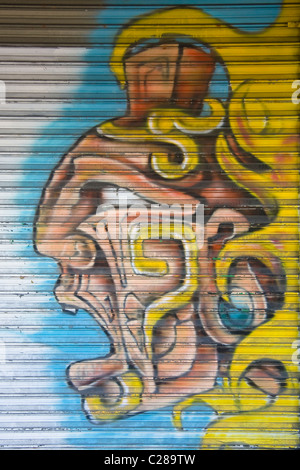 Graffiti art of a Mayan male individual on a corrugated metal store door in Cancun Mexico by an unknown artist Stock Photo
