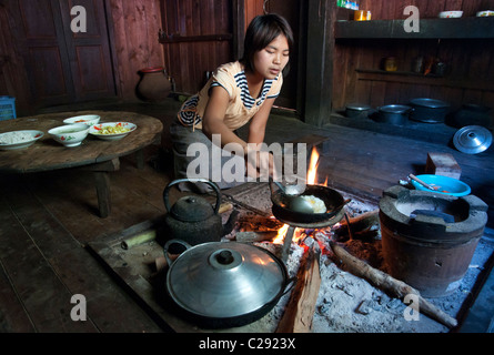 young woman cooking on open fire in wooden house. Mindayik. shan Hills. Myanmar Stock Photo