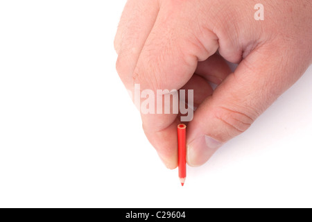 mans hand holding a tiny red pencil on a white background Stock Photo