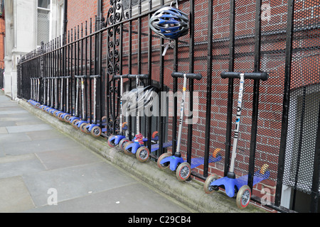 Children's scooters lined up outside the Knightsbridge School, a private day school, Kensington & Chelsea, London, SW3, UK. Stock Photo