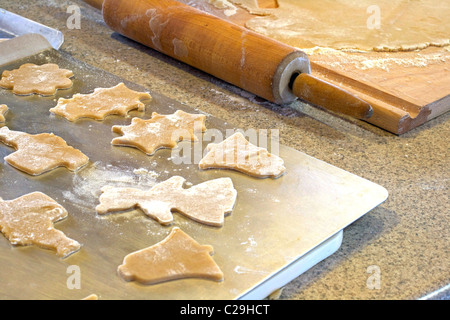 Cutout Christmas Cookies on a baking sheet with a Rolling Pin Nearby Stock Photo