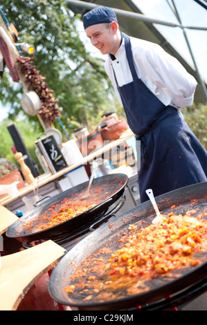 Professional chef cooking & serving traditional Spanish food at the Eden Project, Cornwall, UK Stock Photo