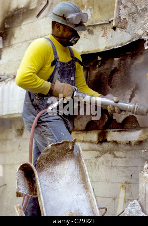Black construction worker demos wall with hammer drill  in downtown San Francisco Stock Photo