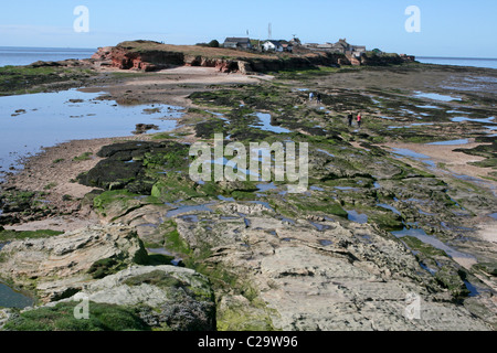 Rocky Shoreline At Low Tide, Looking Towards Hilbre Island, Wirral, UK Stock Photo