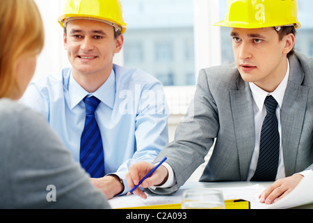 Two architects talking to their colleagues Stock Photo