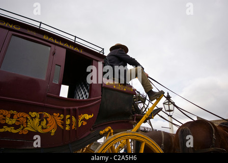 A coachman drives a stagecoach and team of horses. Stock Photo