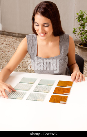 A female architect / designer choosing a glass tile from a group of samples Stock Photo