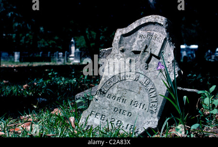 A broken headstone from the 1800s marks a forgotten grave in the Old Protestant Cemetery in historic St. Augustine on the east coast of Florida, USA. Stock Photo