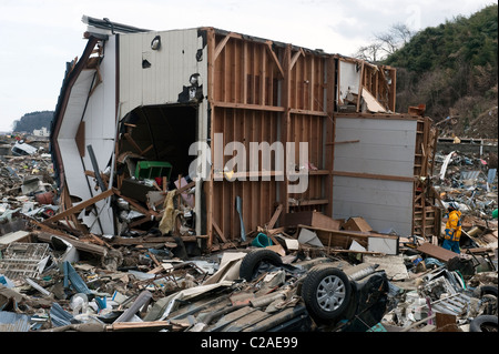 Japanese search and rescue teams search for survivors after thousands of homes were destroyed by the 2011 Tsunami. Stock Photo