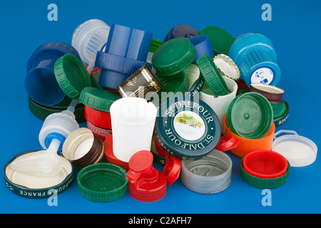 Pile of mixed product bottle and jar tops on a Blue Background Stock Photo