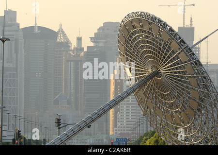 Century Avenue in Pudong, Shanghai in evening sunlight. Sundial sculpture in front, telephoto shot. Stock Photo